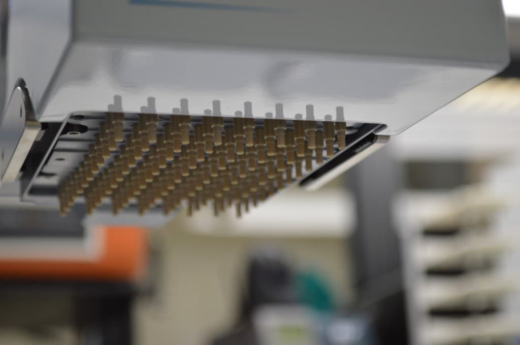 Underside close-up of a multi-channel liquid-handling head with a dense array of pipette tips