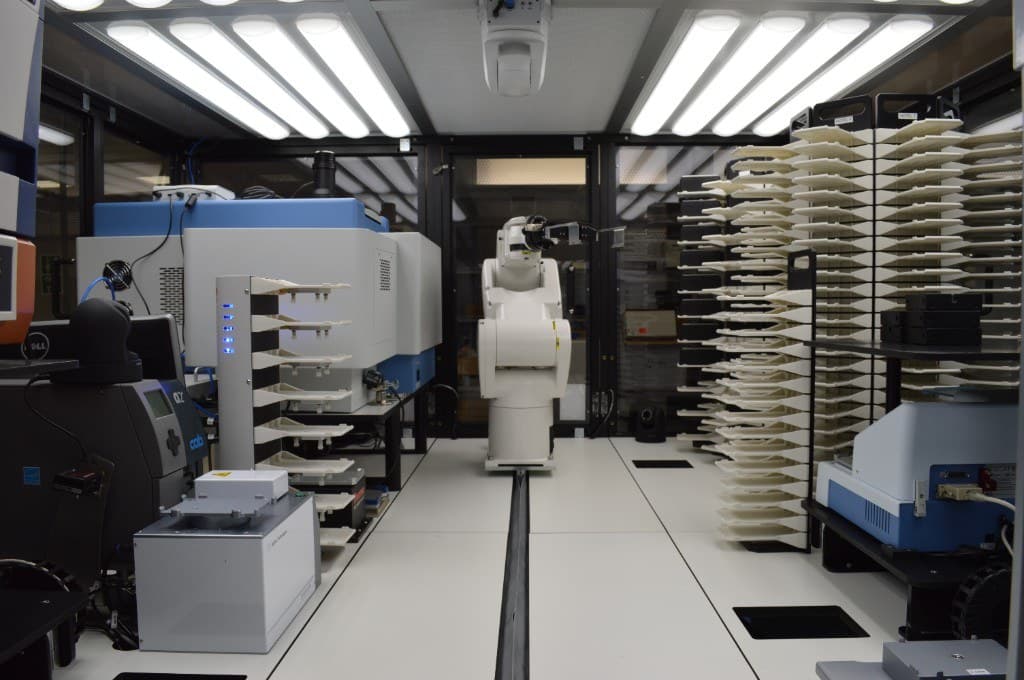 Rail-mounted plate-handling robot between microplate hotels and Agilent instruments inside the HTS enclosure