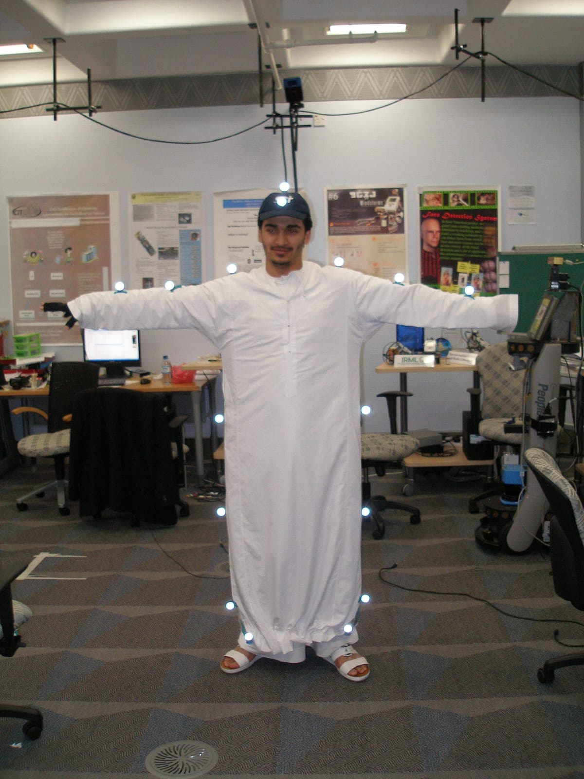 Operator in a motion-capture marker suit holding a T-pose for calibration in the IRML lab